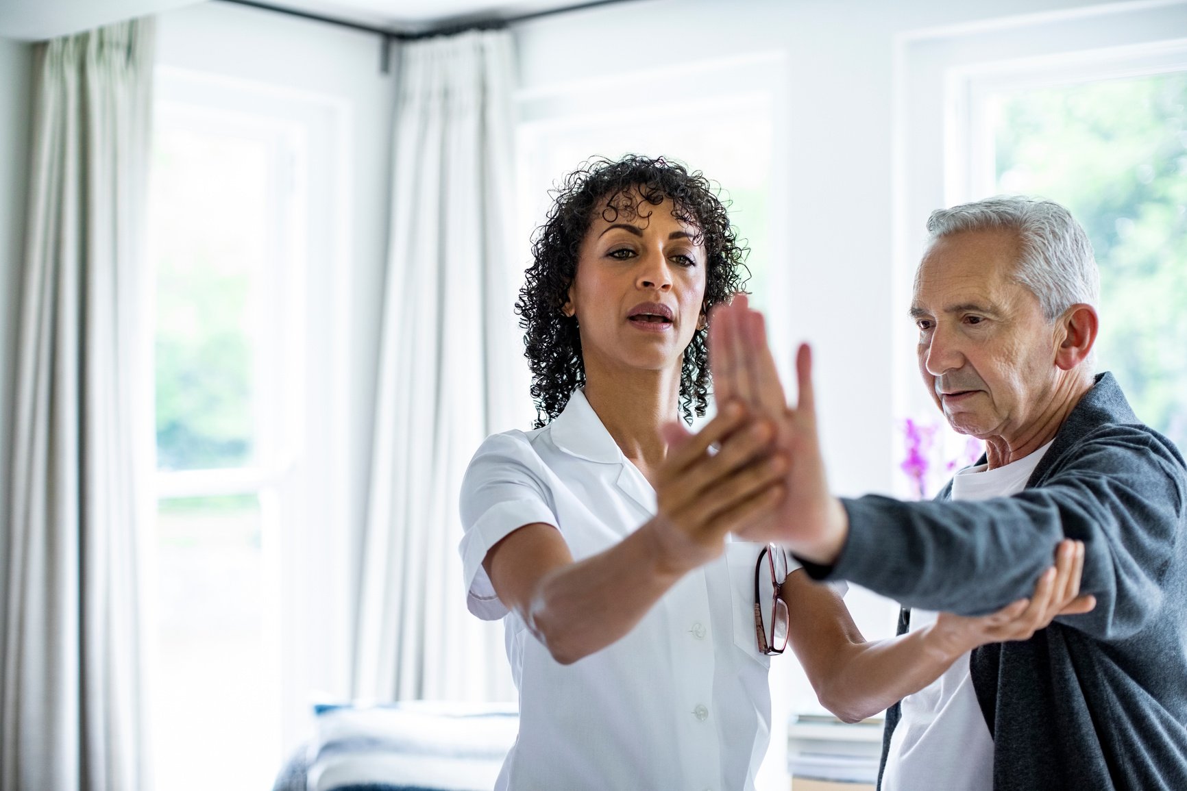 Nurse assisting senior patient in physical therapy